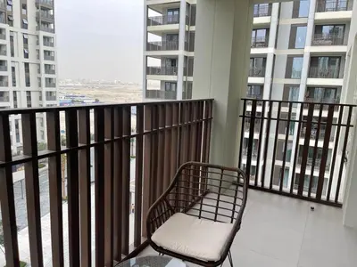 a chair sitting on the balcony of a building at Pearl of Creek Beach: 1BR Luxury Beach Apartment in Dubai