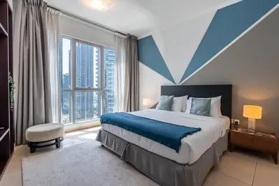 a bedroom with a large bed and a large window at Cozy 1 Bedroom apartment I Downtown Dubai I Near Burj Khalifa in Dubai