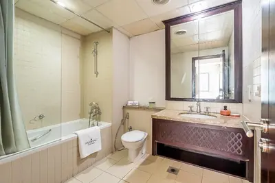 a bathroom with a toilet and a tub and a sink at Cozy 1 Bedroom apartment I Downtown Dubai I Near Burj Khalifa in Dubai