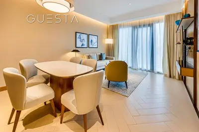 a living room with a table and chairs and a couch at Address Residences Dubai Opera - Burj Khalifa & Fountain View, Downtown Dubai in Dubai