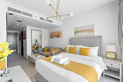 a bedroom with a large bed and a couch at Newly Furnished Studio in JLT in Dubai