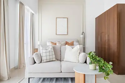 a white living room with a couch and a table at Silkhaus Elegant Studio Near Silicon Central Mall in Dubai