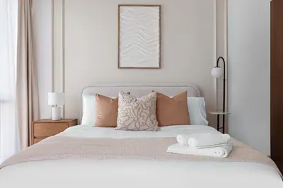a bedroom with a white bed with two towels on it at Silkhaus Elegant Studio Near Silicon Central Mall in Dubai