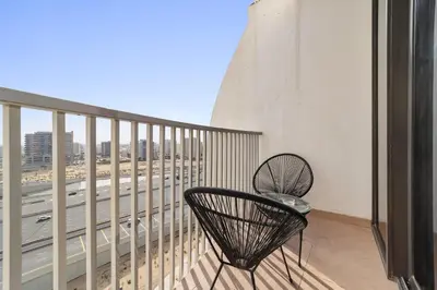 a balcony with a chair and a view of a highway at Silkhaus Modern Studio near Silicon Shopping Mall in Dubai
