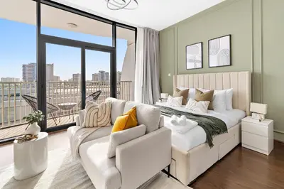 a bedroom with a white bed and a couch at Silkhaus Chic Luxury Studio Opposite Silicon Oasis Shopping Mall in Dubai