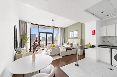 a kitchen and living room with a table and a couch at Silkhaus Chic Luxury Studio Opposite Silicon Oasis Shopping Mall in Dubai