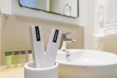 two toothbrushes in a holder next to a sink at Cozy One Bedroom Near Dubai Hills Mall in Dubai