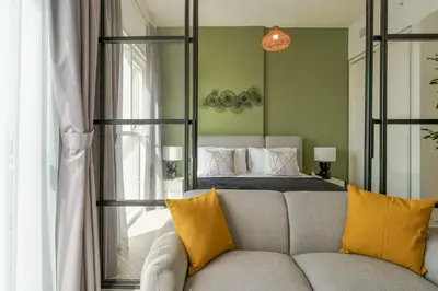 a bedroom with a bed and a couch with a mirror at Cozy One Bedroom Near Dubai Hills Mall in Dubai