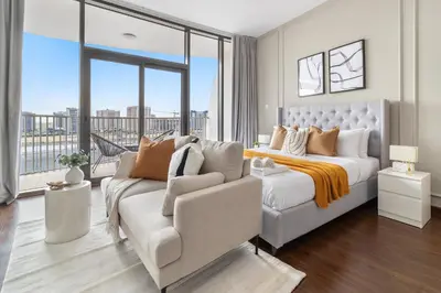 a bedroom with a bed and a couch and a window at Silkhaus Chic Studio Near Silicon Oasis Shopping Mall in Dubai