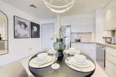 a kitchen with a table with plates and bowls on it at Cozy 1BR Haven in The Cove, Dubai Creek Harbour in Dubai