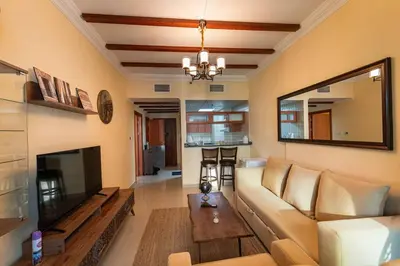 a living room with a couch and a television at Fantastic Apartment near Metro and jbr beach in Dubai
