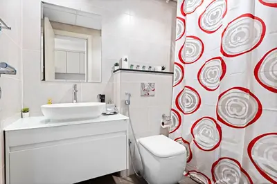a bathroom with a white toilet and a sink at Cozy Studio in Damac Hills in Dubai