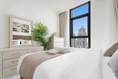 a white bedroom with a large bed and a window at Luxurious 2 BR in Downtown Dubai in Dubai