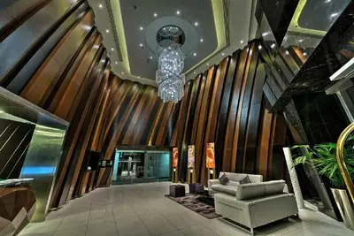 a lobby with a couch and a chandelier at Cayan Tower Dubai Marina - By Home Of Choice in Dubai