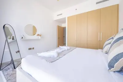 a bedroom with a large white bed and a mirror at Luxury 1BR Retreat l 17 Icon Bay, Dubai Creek in Dubai