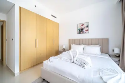 a bedroom with a large bed with white sheets at Luxury 1BR Retreat l 17 Icon Bay, Dubai Creek in Dubai