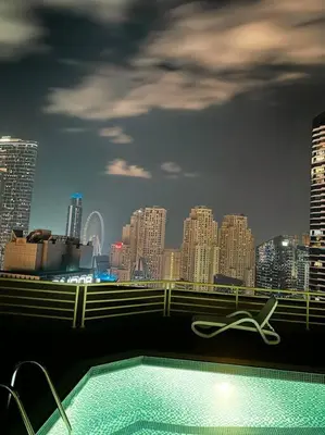 a swimming pool with a city skyline in the background at Lux 1BR w rooftop pool in Marina near metro, Beach in Dubai