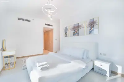 a white bedroom with a large white bed and a stool at Fabulous Missoni Designer Building, 3 bedroom plus maid in Dubai