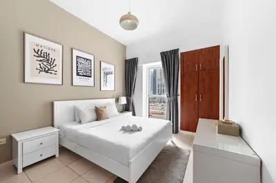 a white bedroom with a white bed and a window at Splendid 1BR APT in Dubai Marina in Dubai