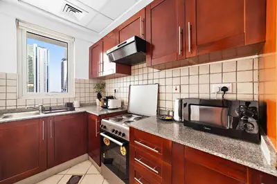 a kitchen with wooden cabinets and a sink and a microwave at Splendid 1BR APT in Dubai Marina in Dubai