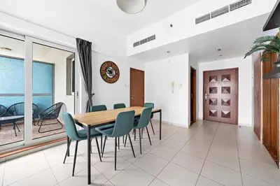 a dining room with a wooden table and chairs at Splendid 1BR APT in Dubai Marina in Dubai