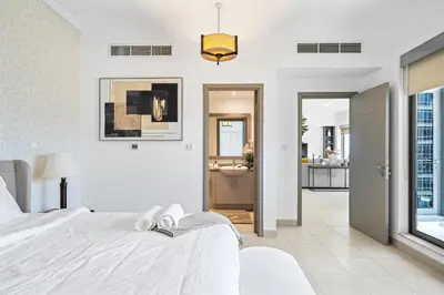 a white bedroom with a bed and a bathroom at Skyline Retreat - South Ridge 2 - Downtown Dubai in Dubai