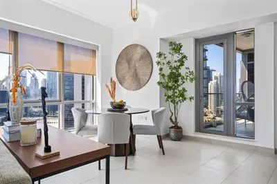 a living room with a table and chairs and a large window at Skyline Retreat - South Ridge 2 - Downtown Dubai in Dubai