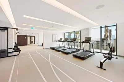 a gym with a row of treadmills and ellipticals at Silkhaus Sea & City View 1BDR in Exclusive Neighbourhood in Dubai
