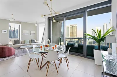 a living room with a table and chairs at Downtown 3BR Sleeps 9 Balcony, Full Kitchen, Near Metro in Dubai