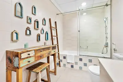 a bathroom with a wooden dresser and a sink and a shower at Apartment KOYO in the heart of JBR Beach - 3BDR in Dubai