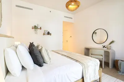 a white bedroom with a bed and a mirror at HiGuests - Luxurious Boho Beach 2BR Apartment in La Mer in Dubai