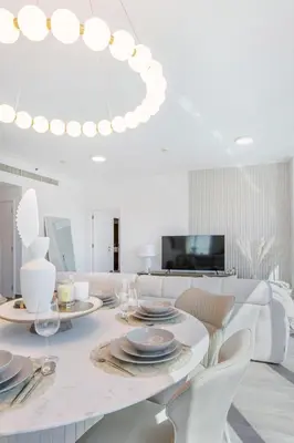a white dining room with a table and chairs at Top-Floor Luxury 2BR with Stunning Marina View in Dubai