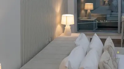 a room with a bed with pillows and a lamp at Top-Floor Luxury 2BR with Stunning Marina View in Dubai