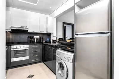 a kitchen with a stainless steel refrigerator and a dishwasher at Panoramic 1BR Stunning Marina Views Near JBR Beach by Maxx Value Homes in Dubai