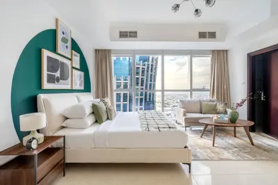 a bedroom with a white bed and a green wall at GuestReady - A Dream Getaway at Business Bay in Dubai