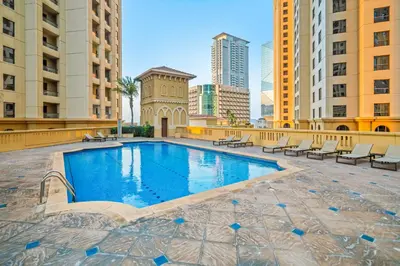a swimming pool in the middle of a city with buildings at Prime Spacious 5 plus 1 BR Apt on JBR Beach near Metro ,Walk to The Mall, Dining & Entertainment - By Sunkissed Holiday Homes in Dubai