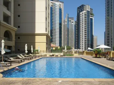 a swimming pool in a city with tall buildings at Prime Specious 4 BR Apt on JBR Beach near Metro, Walk to The Mall, Dining & Entertainment - By Sunkissed Holiday Homes in Dubai
