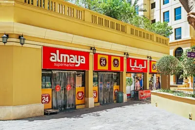an aliya store on the side of a yellow building at Prime Specious 4 BR Apt on JBR Beach near Metro, Walk to The Mall, Dining & Entertainment - By Sunkissed Holiday Homes in Dubai