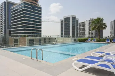 a swimming pool on top of a building with chairs at DAYF-SOL Luxury Living in Business Bay in Dubai