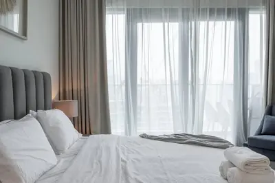 a bedroom with a white bed and a large window at DAYF-SOL Luxury Living in Business Bay in Dubai
