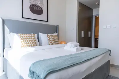 a bedroom with a large white bed with towels on it at Heaven Crest Vacation Homes - Luxury Forte in Dubai