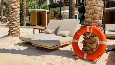 a couch sitting in the sand next to an orange ring at SettlerHomes - Marvelous Lagoon Stay With Pool View in Dubai