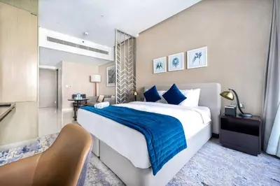 a bedroom with a large bed with a blue blanket at Studio Apartment in DAMAC Maison Prive Business Bay - High Floor in Dubai