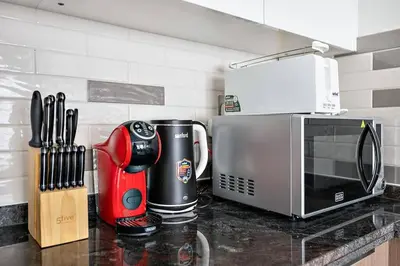 a kitchen counter with a coffee maker and a microwave at Stylish 1 BR in Al Furjan in Dubai