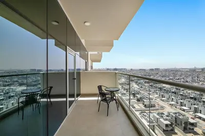 a balcony with tables and chairs and a view of a city at Stylish 1 BR in Al Furjan in Dubai