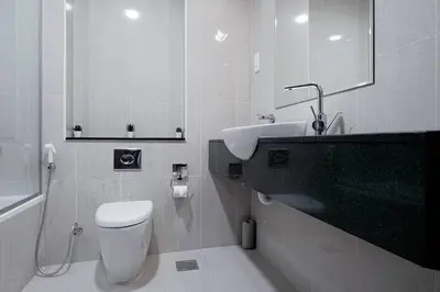 a white bathroom with a sink and a toilet at Cozy Studio in Sports City in Dubai
