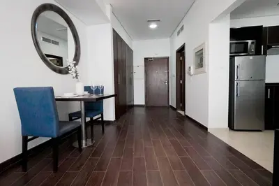 a kitchen and dining room with a table and a mirror at Cozy Studio in Sports City in Dubai
