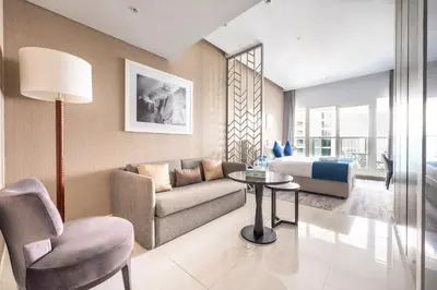 a living room with a couch and a table and a bed at Studio Apartment in DAMAC Maison Prive Businessbay - Dubai Canal View in Dubai