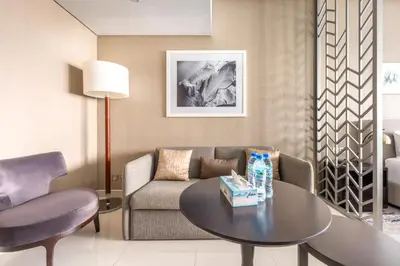 a living room with a couch and a table at Studio Apartment in DAMAC Maison Prive Businessbay - Dubai Canal View in Dubai
