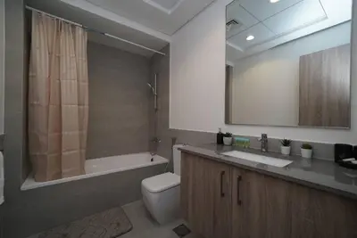 a bathroom with a tub and a toilet and a sink at Spacious 1 BR in Peaceful Community in Dubai